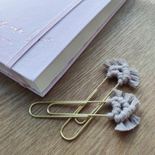 Load image into Gallery viewer, Kaksi harmaata makramee-klemmaria pöydällä, taka-alalla vaaleanpunainen muistikirja.