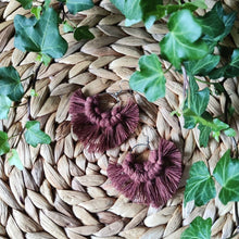 Load image into Gallery viewer, Sunburst macramé earrings in a shade Milk Chocolate, laying flat on a straw place mat, green leaves on the sides.