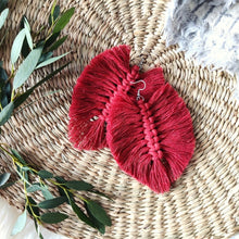 Load image into Gallery viewer, The Feather Girls macramé earrings in colour Rust, green eucalyptus leaves on the left side of the picture.