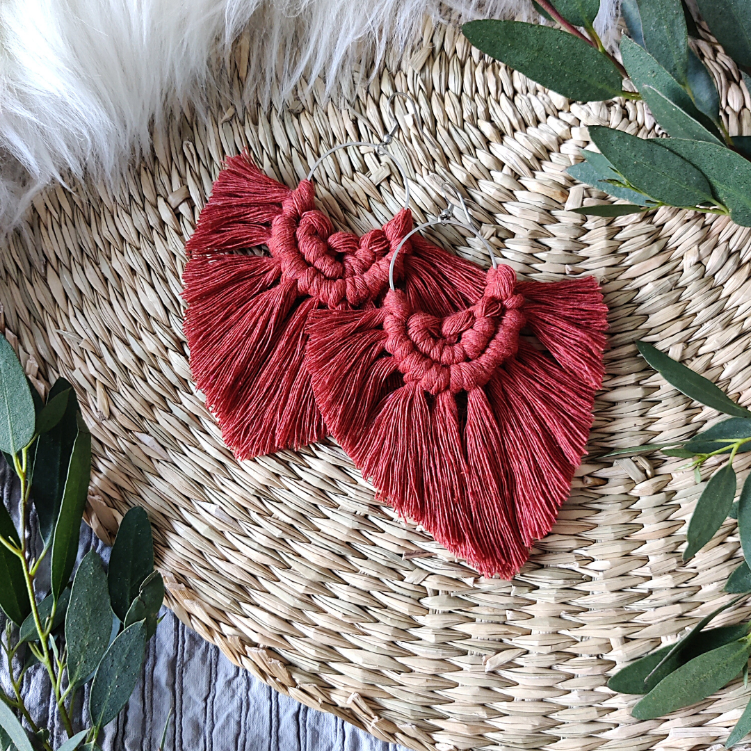 Rust coloured macramé earrings, green eucalyptus leaves on the sides.