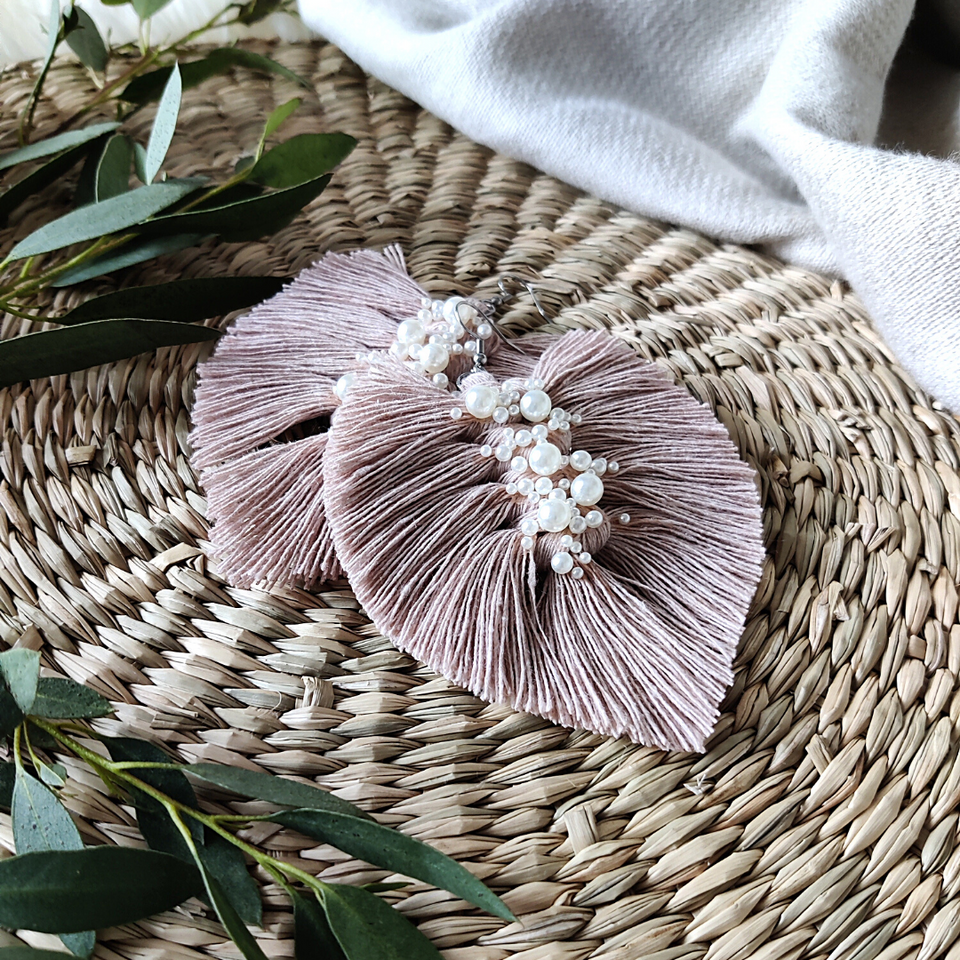 Dusty rose coloured Uptown Pearl macramé earrings with eucalyptus leaves on the left side.