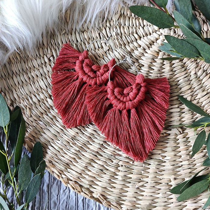 Rust coloured Boho Babe macramé earrings, eucalyptus leaves on the edges of the picture.