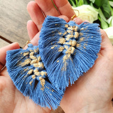 Load image into Gallery viewer, Gold Digger macramé earrings in colour Night Sky with gold paint splatters, laying in a models hands.
