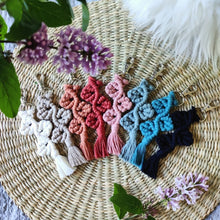 Load image into Gallery viewer, Rainbow of Grapevine Macramé Keychains in different colours, lilac flowers on the sides.
