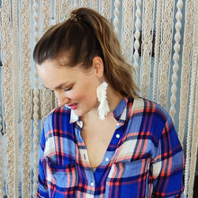Load image into Gallery viewer, Model in a blue shirt wearing The Feather Girls macramé earrings in colour Natural.
