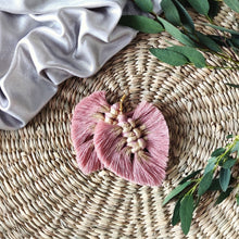 Load image into Gallery viewer, Gold Digger macramé earrings in colour Vintage Rose with gold paint splatters, green eucalyptus leaves on the right side of the picture.
